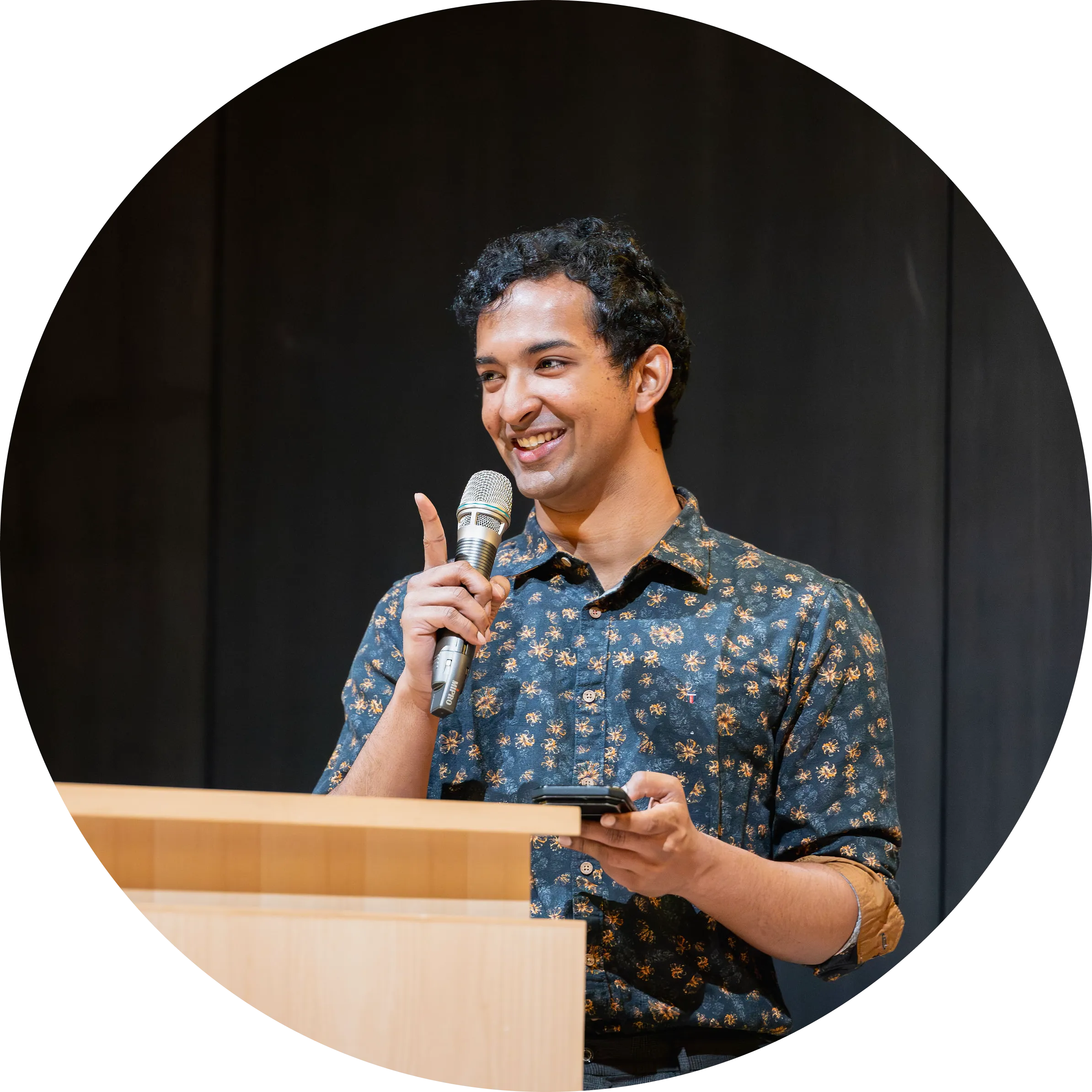 Asher Damla speaking at a podium.