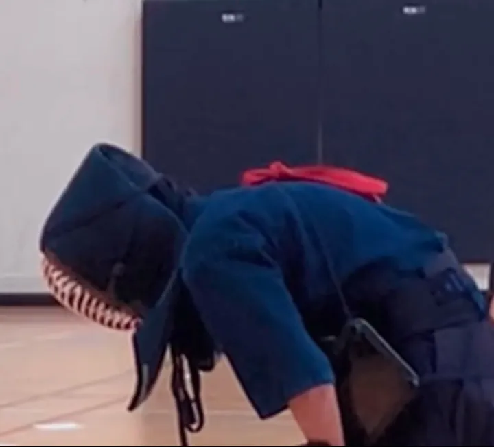 A club member in bogu, bowing during a training session.
